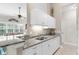 Well-lit kitchen with white cabinetry, granite countertops, and views into the living area at 129 Preserve Pl # D, Nokomis, FL 34275