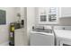 Functional laundry room featuring modern machines, a sink, and a water heater for efficient household chores at 129 Preserve Pl # D, Nokomis, FL 34275