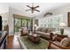Cozy living room featuring plantation shutters, comfortable seating, and a ceiling fan at 129 Preserve Pl # D, Nokomis, FL 34275