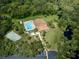 Aerial view of community center with pool, tennis court, lush landscaping and parking at 1320 Whispering Ln, Venice, FL 34285