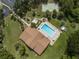 Aerial view of a community pool, tennis court, and surrounding landscaping at 1320 Whispering Ln, Venice, FL 34285