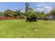 Lush backyard with mature trees and well-maintained lawn at 1320 Whispering Ln, Venice, FL 34285