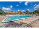 Community pool surrounded by lounge chairs and a beautiful community center at 1320 Whispering Ln, Venice, FL 34285