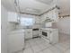 Bright kitchen featuring white cabinets, tile flooring and a window above the sink at 1320 Whispering Ln, Venice, FL 34285