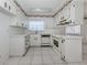 Bright kitchen featuring white cabinets, and tile flooring at 1320 Whispering Ln, Venice, FL 34285