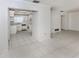 View of the kitchen area from the living room featuring white appliances and tile floor at 1320 Whispering Ln, Venice, FL 34285