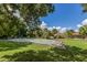 Community shuffleboard court with benches, nearby community center, and lush greenery at 1320 Whispering Ln, Venice, FL 34285