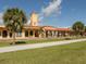 Historic train depot with arches and a tower, featuring a red-tiled roof and manicured green lawn at 1320 Whispering Ln, Venice, FL 34285