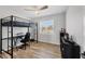 Cozy bedroom featuring a unique loft bed with desk, hardwood floors, and bright natural light at 13579 Romford Ave, Port Charlotte, FL 33981