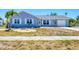 Charming single-story home featuring a light blue exterior and well-maintained front yard, perfect for curb appeal at 13579 Romford Ave, Port Charlotte, FL 33981