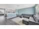 Spacious living room featuring a modern gray sectional, adjacent to an open concept kitchen with lots of light at 13579 Romford Ave, Port Charlotte, FL 33981