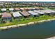 An aerial view features a waterfront home with lush landscaping in a vibrant community at 13731 Vadini St, Venice, FL 34293
