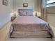 Cozy bedroom with a grey wood-look platform bed and soft, neutral bedding, lit by two bedside lamps at 13731 Vadini St, Venice, FL 34293