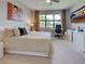Inviting bedroom featuring a large window, ceiling fan, and a comfortable bed with a workspace at 13731 Vadini St, Venice, FL 34293