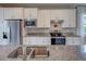 Well-lit kitchen with stainless steel appliances, white cabinetry, and granite countertops at 13731 Vadini St, Venice, FL 34293