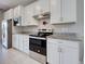 Updated kitchen with granite countertops, stainless steel appliances, and white cabinetry at 13731 Vadini St, Venice, FL 34293