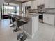 Kitchen showcasing stainless steel appliances, granite countertops, and a large island with bar seating at 13731 Vadini St, Venice, FL 34293