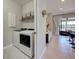 Bright laundry room with modern appliances, storage shelves, and convenient access from the kitchen at 13731 Vadini St, Venice, FL 34293
