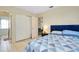 Bedroom view of a bed with blue accents and a closet with an adjoining bathroom at 144 Rotonda Cir, Rotonda West, FL 33947