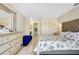 Well-lit bedroom with light-colored walls, tiled floors, and an ensuite bathroom at 144 Rotonda Cir, Rotonda West, FL 33947