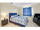 Bedroom showcasing a bed with a blue patterned quilt, side table, and a TV stand at 144 Rotonda Cir, Rotonda West, FL 33947