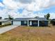 Inviting home with a well-manicured lawn and a driveway, showcasing lovely curb appeal at 144 Rotonda Cir, Rotonda West, FL 33947
