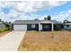 Charming single-story home with a well-maintained lawn and a spacious two-car garage at 144 Rotonda Cir, Rotonda West, FL 33947