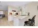 Eat-in kitchen area featuring white cabinetry, breakfast bar, and tiled flooring at 144 Rotonda Cir, Rotonda West, FL 33947