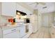 Bright kitchen featuring white cabinets and appliances, with convenient access to adjacent rooms at 144 Rotonda Cir, Rotonda West, FL 33947