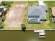 Aerial view of waterfront home with private boat dock, pool, and adjacent vacant lot at 15448 Avery Rd, Port Charlotte, FL 33981