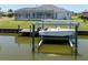 A boat dock and boat lift on the canal behind the house provide convenient waterfront access at 15448 Avery Rd, Port Charlotte, FL 33981