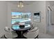Bright dining area with round table overlooking the pool and water views through large windows at 15448 Avery Rd, Port Charlotte, FL 33981