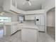Bright kitchen featuring white cabinetry, a central island, and views to the lanai at 15448 Avery Rd, Port Charlotte, FL 33981