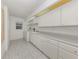 Functional laundry room with tiled floors, ample cabinet storage, and washer dryer at 15448 Avery Rd, Port Charlotte, FL 33981
