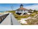 Quaint historic lighthouse with a connecting raised walkway, on sandy shores with a clear blue sky overhead at 15448 Avery Rd, Port Charlotte, FL 33981