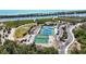Aerial view of neighborhood tennis courts with professional surfacing in a beautiful, natural setting near the water at 1568 Ringtail Rd, Venice, FL 34293
