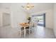 Bright dining area with tile floors, white furniture, and sliding glass doors to the pool area at 1568 Ringtail Rd, Venice, FL 34293