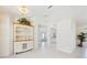 Bright entryway featuring tile flooring, a decorative cabinet with wooden accents, and an open floor plan at 1568 Ringtail Rd, Venice, FL 34293