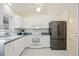 Modern kitchen featuring white cabinetry, stainless steel appliances, and tiled backsplash at 1568 Ringtail Rd, Venice, FL 34293