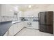 Well-lit kitchen boasting white cabinets, stainless steel appliances, and a practical layout for cooking and entertaining at 1568 Ringtail Rd, Venice, FL 34293