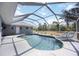 Screened-in pool with lounge chairs, tile surround, and view of the backyard at 1568 Ringtail Rd, Venice, FL 34293