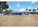 Backyard view of home showcasing a screen enclosed patio, with a large lawn at 1568 Ringtail Rd, Venice, FL 34293