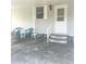 View of covered carport showing chairs and tables. Entry door is visible with porch at 177 Palm Harbor Dr, North Port, FL 34287