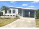 Inviting home featuring a covered carport, well-maintained lawn, and charming front entryway at 177 Palm Harbor Dr, North Port, FL 34287