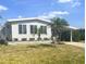 Single-story home boasts mature landscaping, vibrant green grass, and a covered carport at 177 Palm Harbor Dr, North Port, FL 34287