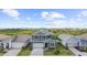 Aerial view of a two-story home with a gray facade, featuring a well-kept lawn and brick-paved driveway at 18001 Grand Prosperity Dr, Venice, FL 34293