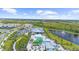 Aerial view shows community clubhouse with a pool, and lush landscaping, offering a resort-like experience for residents and guests at 18001 Grand Prosperity Dr, Venice, FL 34293