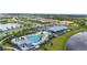 Aerial view showcases the community clubhouse, pool, and lush green surroundings, creating a serene and inviting atmosphere at 18001 Grand Prosperity Dr, Venice, FL 34293