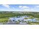 Aerial view of a stunning community clubhouse, pool, and surrounding green landscape with a scenic pond and fountain at 18001 Grand Prosperity Dr, Venice, FL 34293