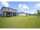 Expansive backyard with lush green lawn and the rear exterior of a two-story home at 18001 Grand Prosperity Dr, Venice, FL 34293
